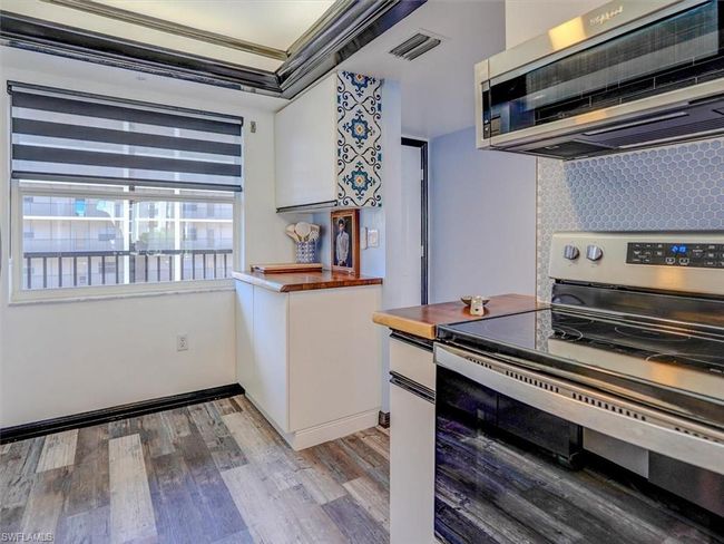 KITCHEN VIEW. CUSTOM ZEBRA SHADES. ENTRANCE TO UNIT SHOWN MIDDLE REAR. | Image 15