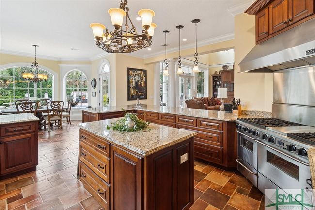 Two sinks, an Island and expansive granite countertops provide plenty of area for prep work as well as additinal seating. | Image 13