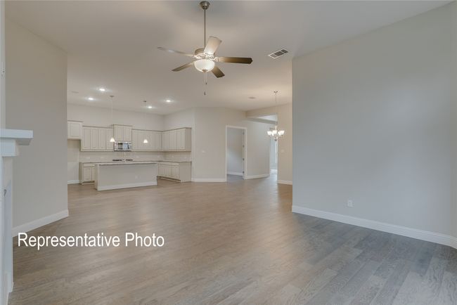 Unfurnished living room featuring a chandelier, a ceiling fan, light wood-style floors, and recessed lighting | Image 6