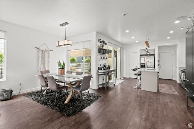 Dining space with dark wood-style flooring, recessed lighting, and a chandelier | Image 10