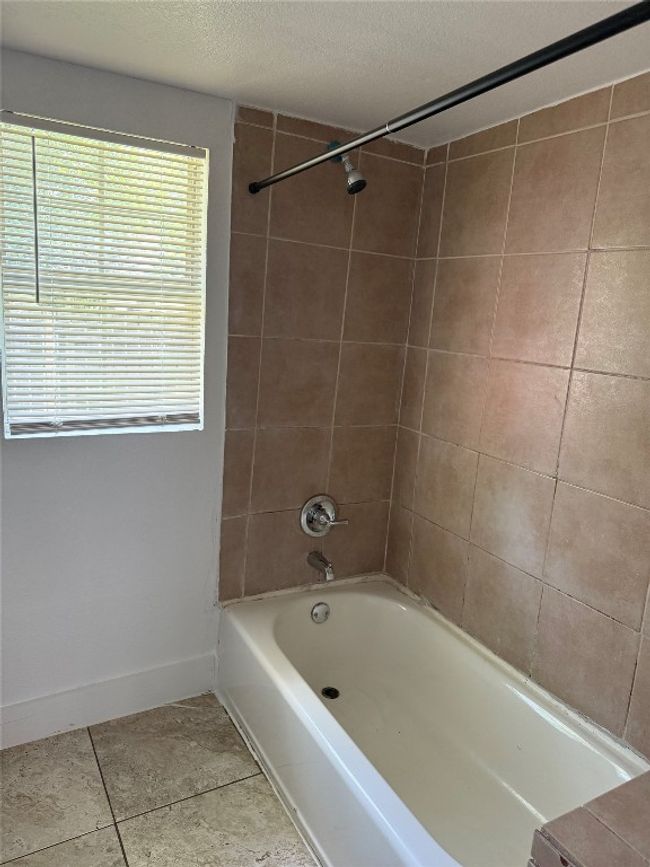 Bathroom with tub / shower combination and tile patterned floors | Image 4