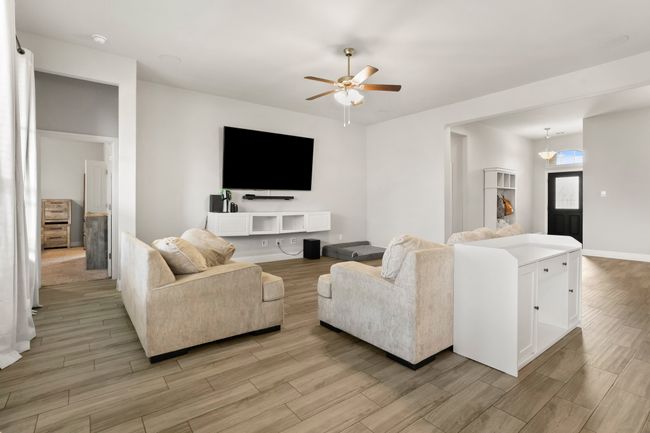 Living area featuring ceiling fan and light wood-style floors | Image 5