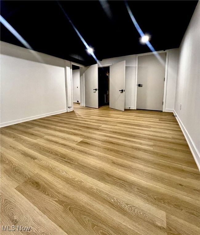 Finished below grade area featuring baseboards and light wood-style floors | Image 18