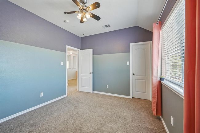 Unfurnished bedroom with carpet floors, lofted ceiling, baseboards, and a ceiling fan | Image 32