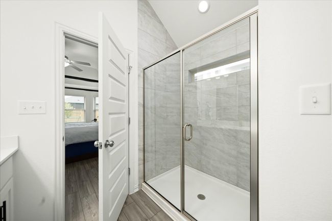 Full bath featuring vanity, wood tiled floor, ensuite bath, a shower stall, and vaulted ceiling | Image 22