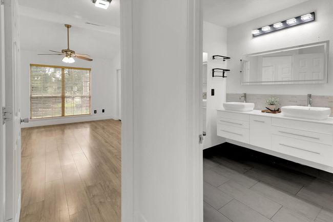Full bath featuring double vanity, dark wood finished floors, and ceiling fan | Image 12