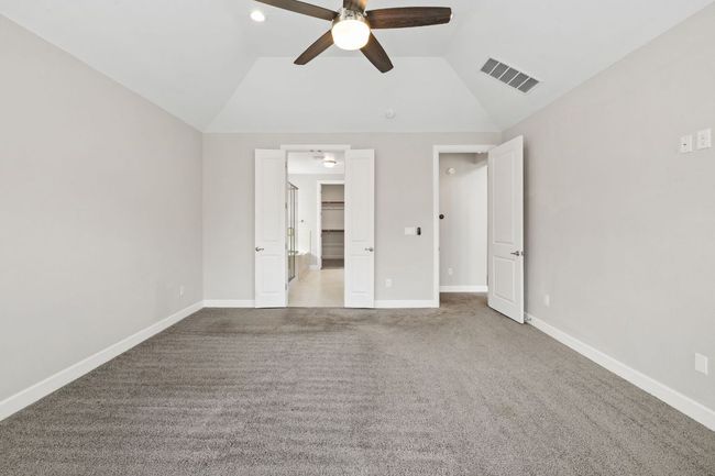 Unfurnished bedroom with a spacious closet, carpet, baseboards, visible vents, and lofted ceiling | Image 20