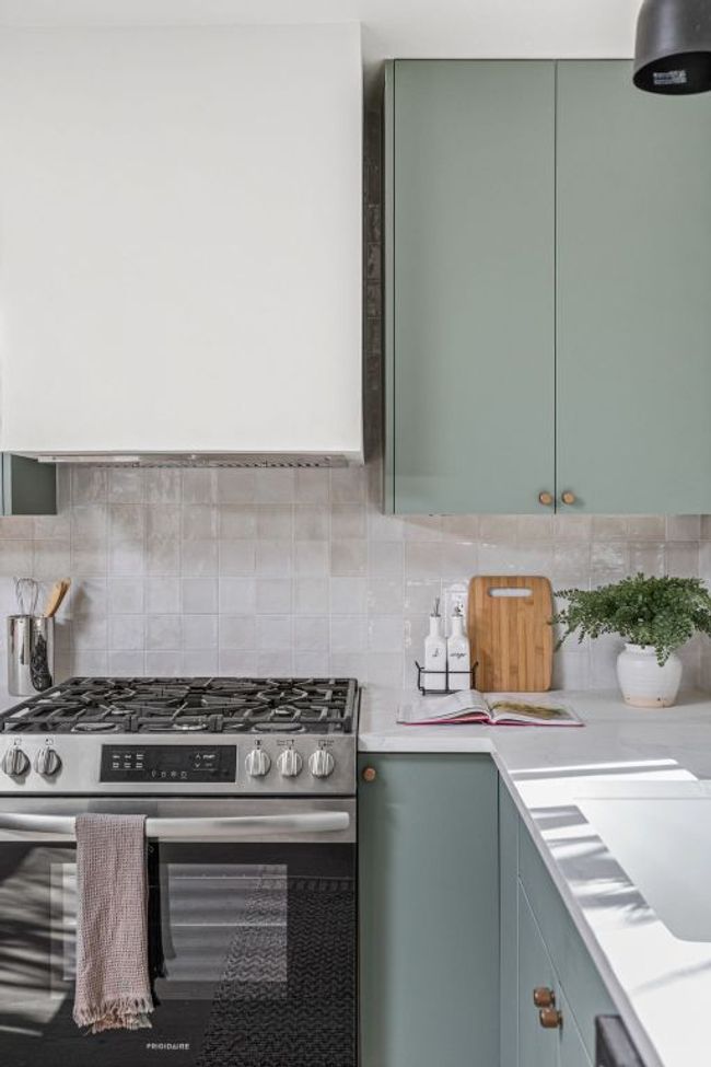 Kitchen featuring stainless steel gas stove, green cabinets, light countertops, and tasteful backsplash | Image 20