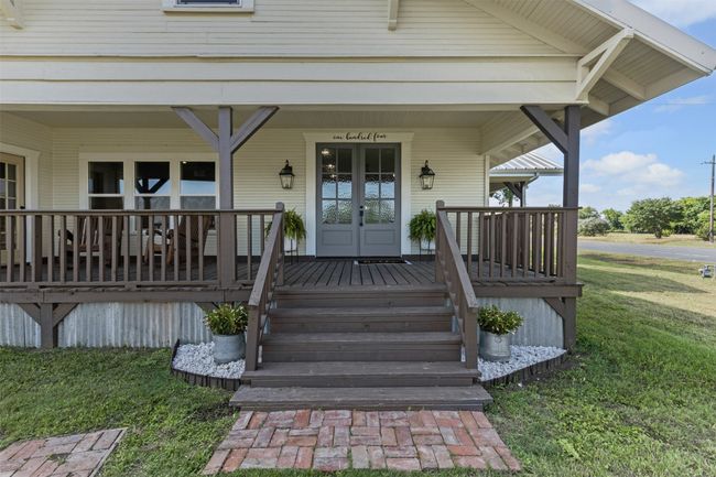 Entrance to property featuring covered porch, a yard, and french doors | Image 6
