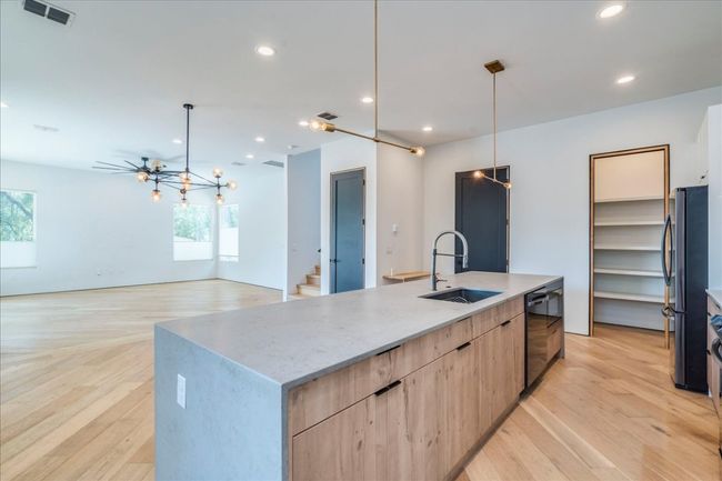 Kitchen featuring light brown cabinetry, black dishwasher, modern cabinets, freestanding refrigerator, and light wood-type flooring | Image 10
