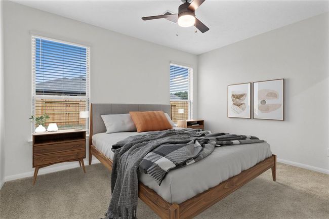 Come and unwind after a long day in this magnificent primary suite! This spacious room features plush carpet, warm paint, high ceilings with ceiling fan, and large windows with privacy blinds. | Image 11
