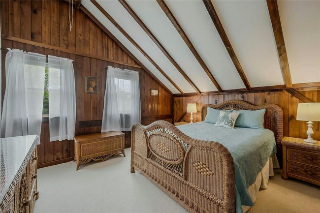 Bedroom featuring wood walls and light carpet | Image 11