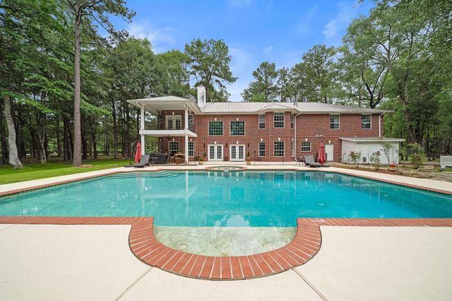 The home features a large pool and a spacious patio area | Image 11