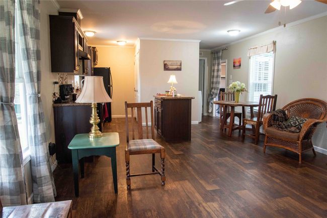 Living room area looking toward the kitchen and dining area. | Image 19