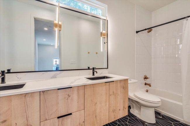 Bathroom featuring vanity, tub / shower combination, and tile patterned flooring | Image 21
