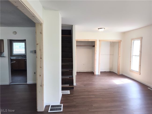 Unfurnished bedroom with two closets, wood finished floors, and baseboards | Image 13