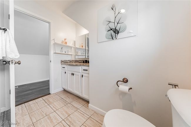 Bathroom featuring baseboards, toilet, and vanity | Image 30