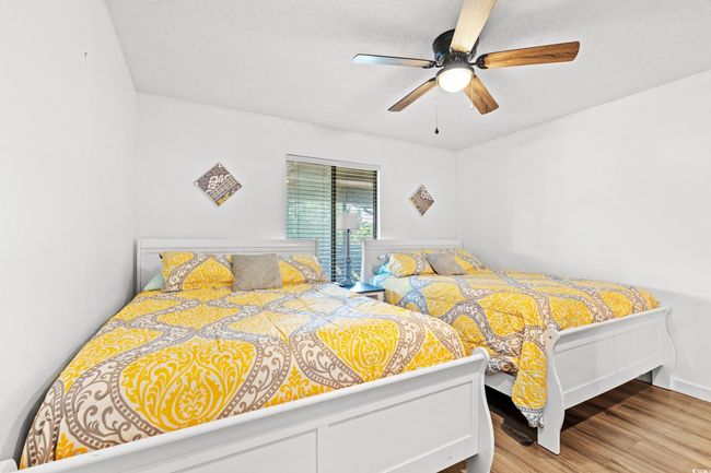Bedroom featuring wood finished floors, ceiling fan, and a textured ceiling | Image 18