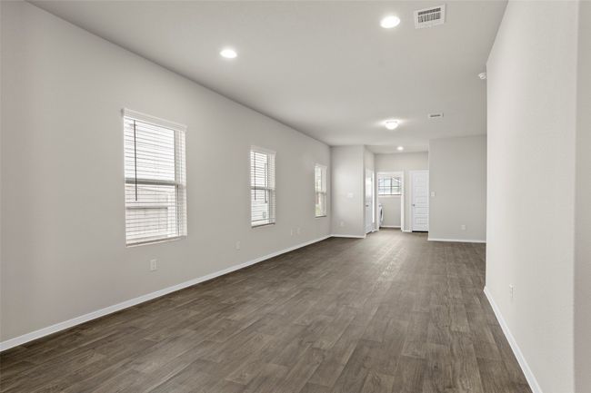 Empty room featuring dark wood-style flooring, baseboards, visible vents, and recessed lighting | Image 12