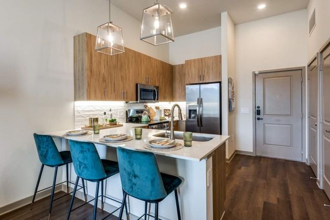 Kitchen with sink, a breakfast bar, stainless steel appliances, decorative light fixtures, and kitchen peninsula | Image 6