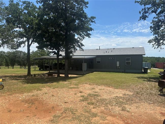 Rear view of house with a lawn, a carport, and a patio area | Image 6