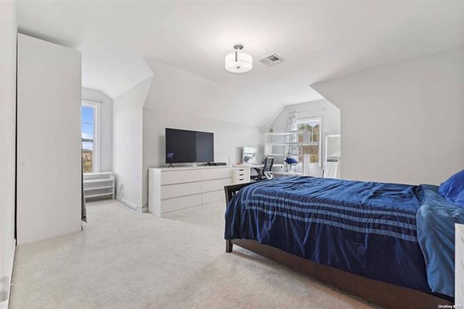 Carpeted bedroom with lofted ceiling | Image 13