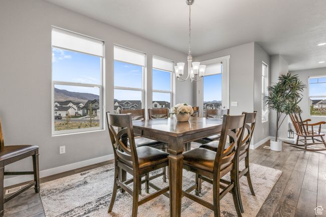 Dining space featuring a chandelier, wood-type flooring, baseboards, and recessed lighting | Image 13