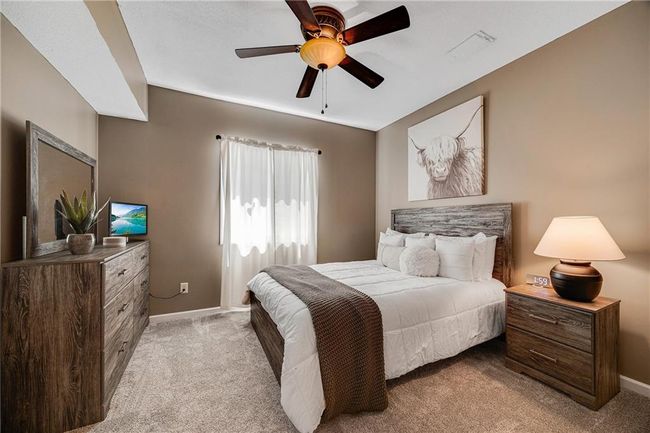 Lower level bedroom with carpet, ceiling fan and a walk in closet. | Image 46