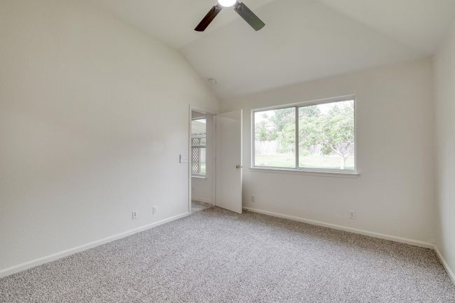 Spare room featuring ceiling fan, vaulted ceiling, and light carpet | Image 16