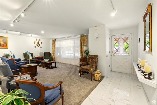 Living area featuring rail lighting, plenty of natural light, and light marble finish floors | Image 6