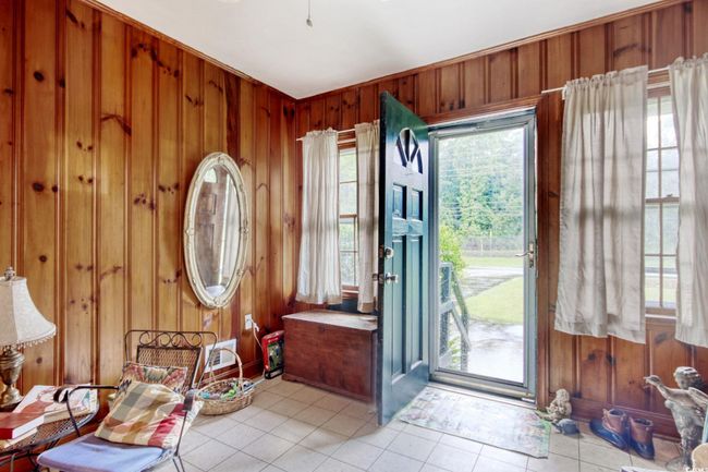 Entrance foyer featuring wooden walls and light tile patterned floors | Image 7