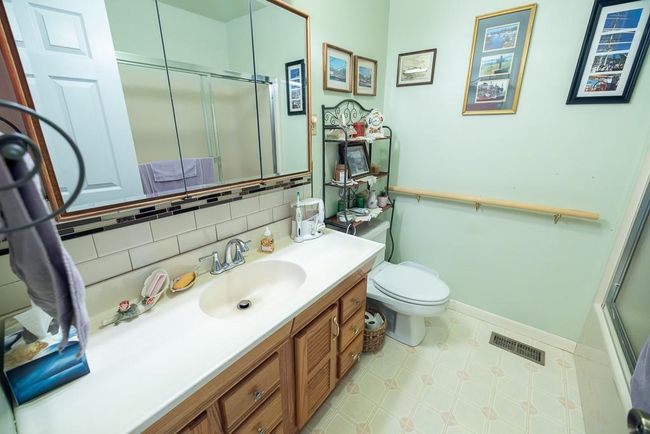 Bathroom with walk in shower, vanity, backsplash, and toilet | Image 16