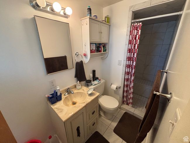 Bathroom with toilet, vanity, a shower stall, and tile patterned flooring | Image 15
