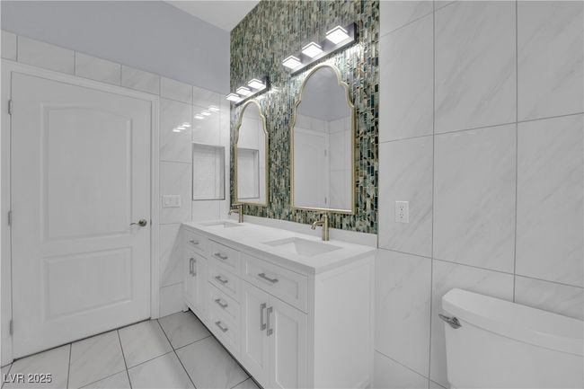Full bathroom featuring tile walls, double vanity, and tile patterned floors | Image 23