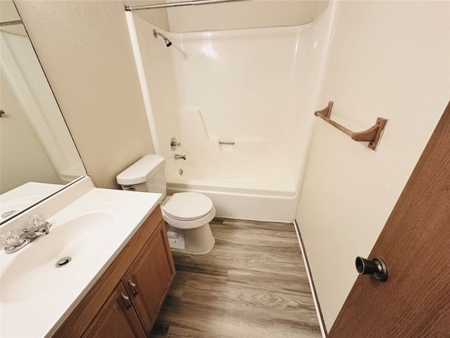 Bathroom featuring wood finished floors, vanity, and shower combination | Image 28