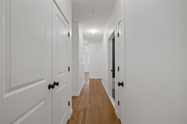 Hallway with light wood-type flooring and baseboards | Image 19