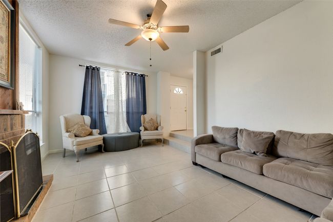 Tiled living room featuring a textured ceiling and ceiling fan | Image 4