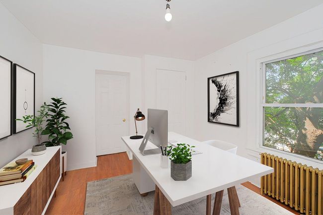 Home office featuring radiator heating unit and light wood-style flooring | Image 9