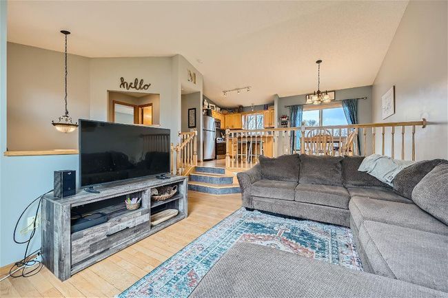 The layout of the living room being just a few steps down from the kitchen/dining area creates a cozy and inviting atmosphere, perfect for relaxing or entertaining guests! | Image 7