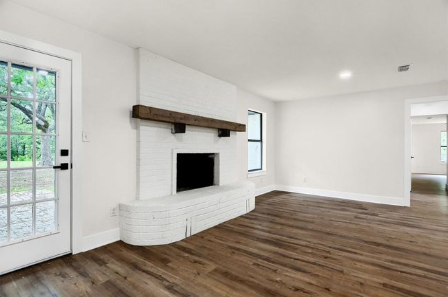Unfurnished living room featuring dark wood-style floors, healthy amount of natural light, and baseboards | Image 6