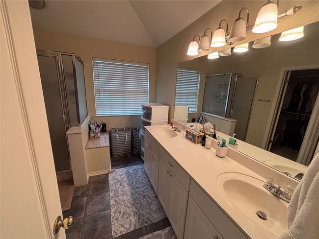 Bathroom with lofted ceiling, a shower stall, double vanity, and a spacious closet | Image 16