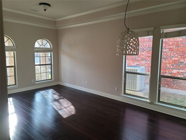 Empty room with crown molding and dark wood-style floors | Image 7
