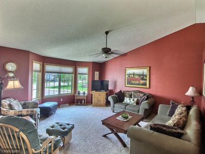 Living room has vaulted ceilings and lots of natural lighting. | Image 2