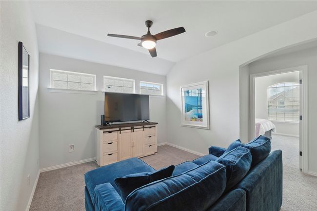 Living room with light carpet, healthy amount of natural light, a ceiling fan, and lofted ceiling | Image 29