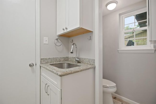 Half bath and utility room located downstairs. | Image 21