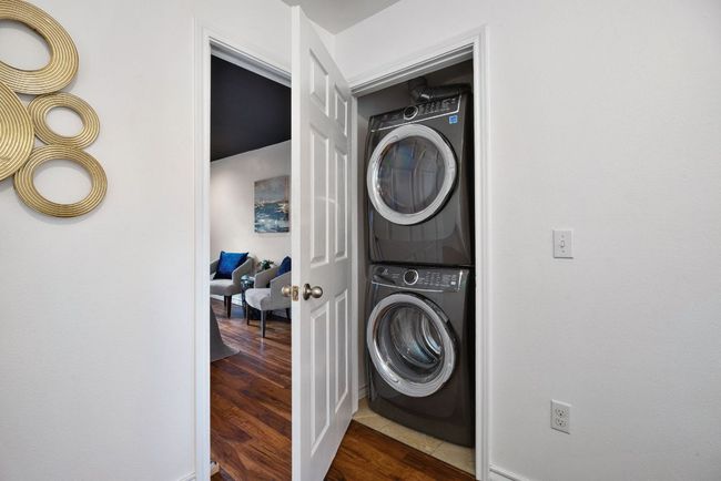 Laundry closet with stacked washing machine and dryer and dark wood-type flooring | Image 31