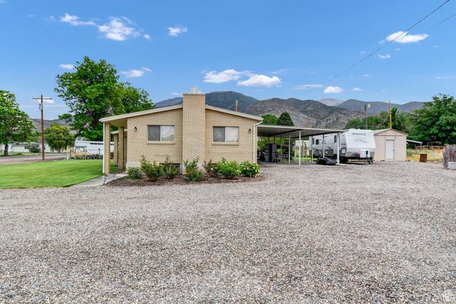 View of side of property featuring driveway, a mountain view, a carport, a chimney, and brick siding | Image 5