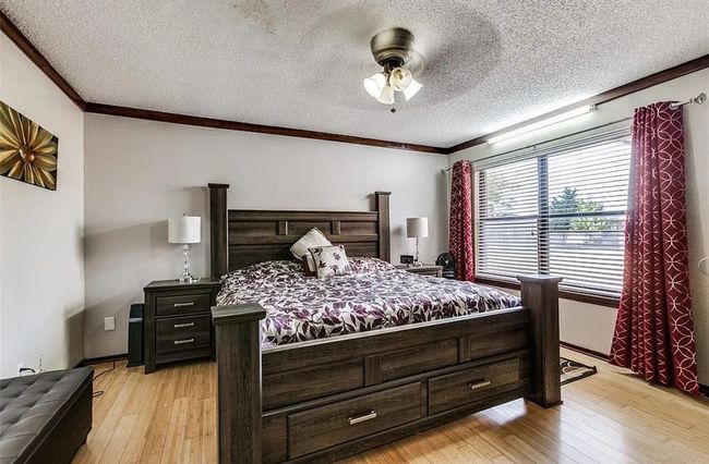 Bedroom featuring ornamental molding, light wood finished floors, a textured ceiling, and a ceiling fan | Image 9