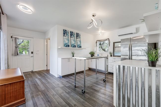 Inside, the cozy Kitchen are trendy light fixtures, a refrigerator, sink, and counterspace...great area for a hotplate and toaster oven. | Image 34
