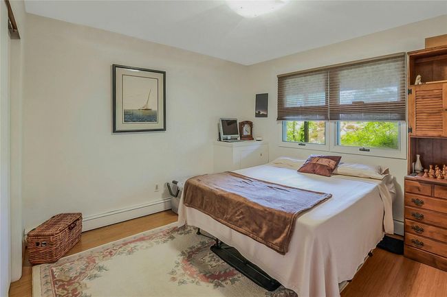 Bedroom with baseboard heating and light wood finished floors | Image 6